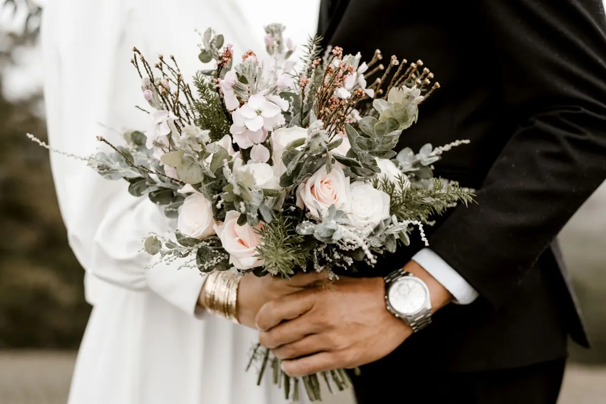 Couple holding the bridal bouquet, wedding gallery